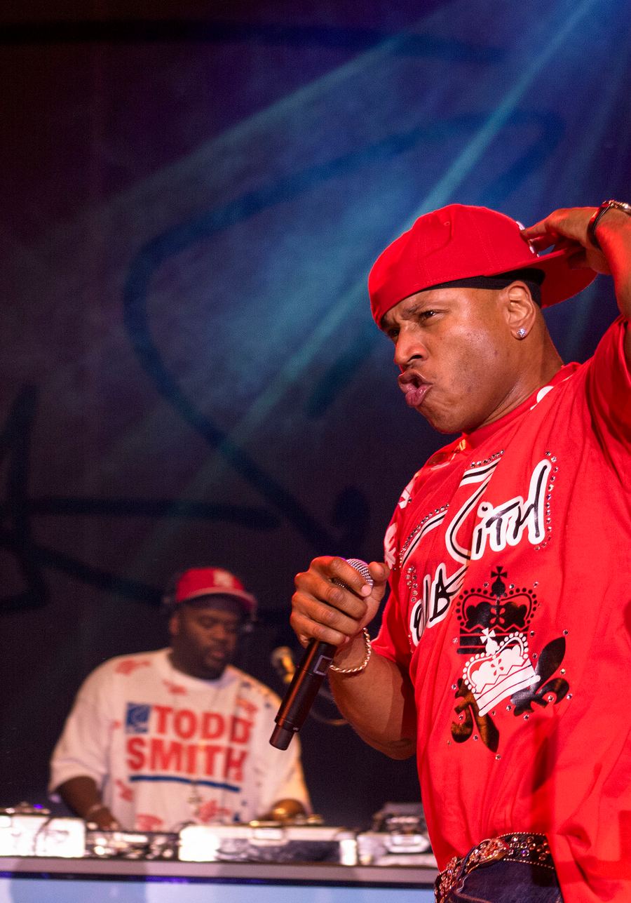 Rapper LL Cool J performt mit Mikrofon auf der Bühne, im Hintergrund ein DJ