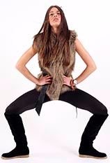 Portrait einer jungen Frau im Fellweste-Look in dynamischer Pose