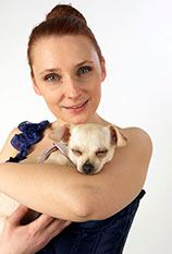 Portrait einer Frau, die einen kleinen Hund im Arm hält