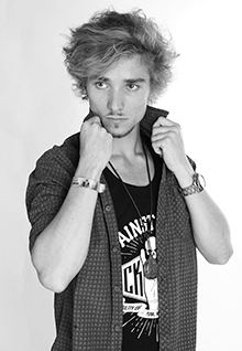 Portrait eines jungen Mannes mit lockigem Haar in lässiger Pose