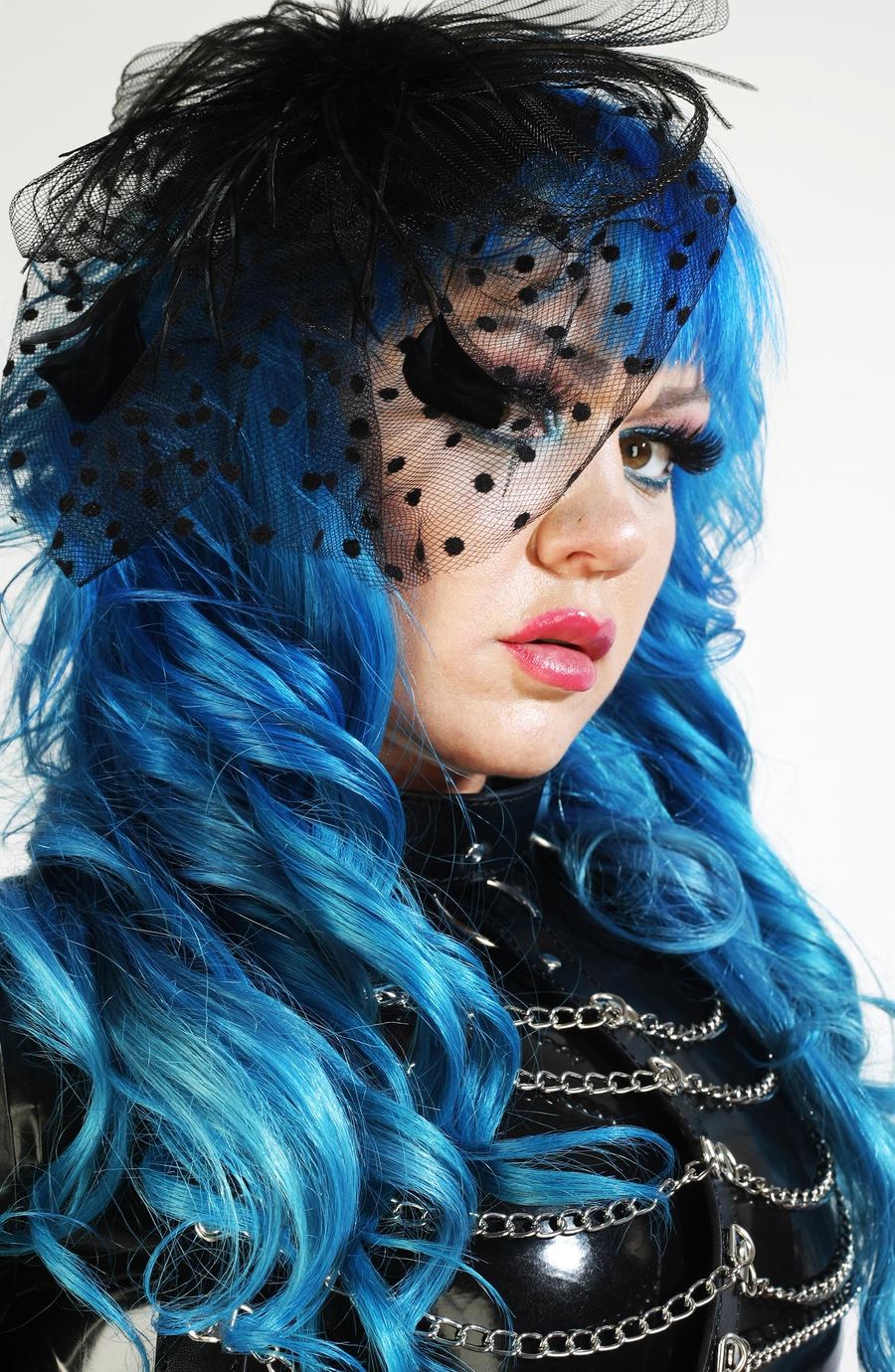 Editorial-Nahaufnahme einer Frau mit blauen Haaren und schwarzem Schleier